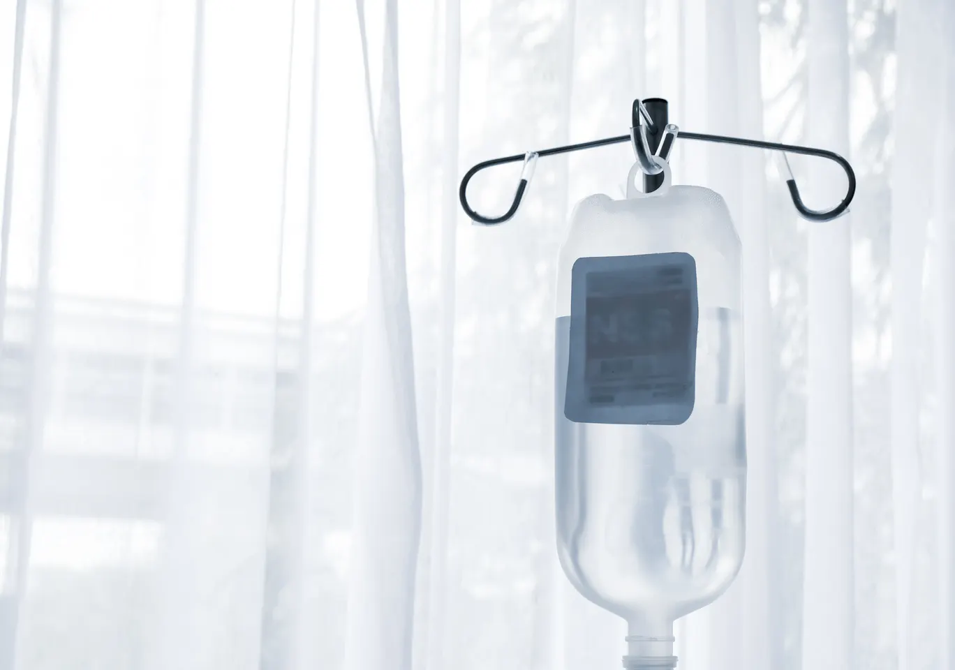 Kroplówki witaminowe Lębork: butelka płynu infuzyjnego zawieszona przy oknie